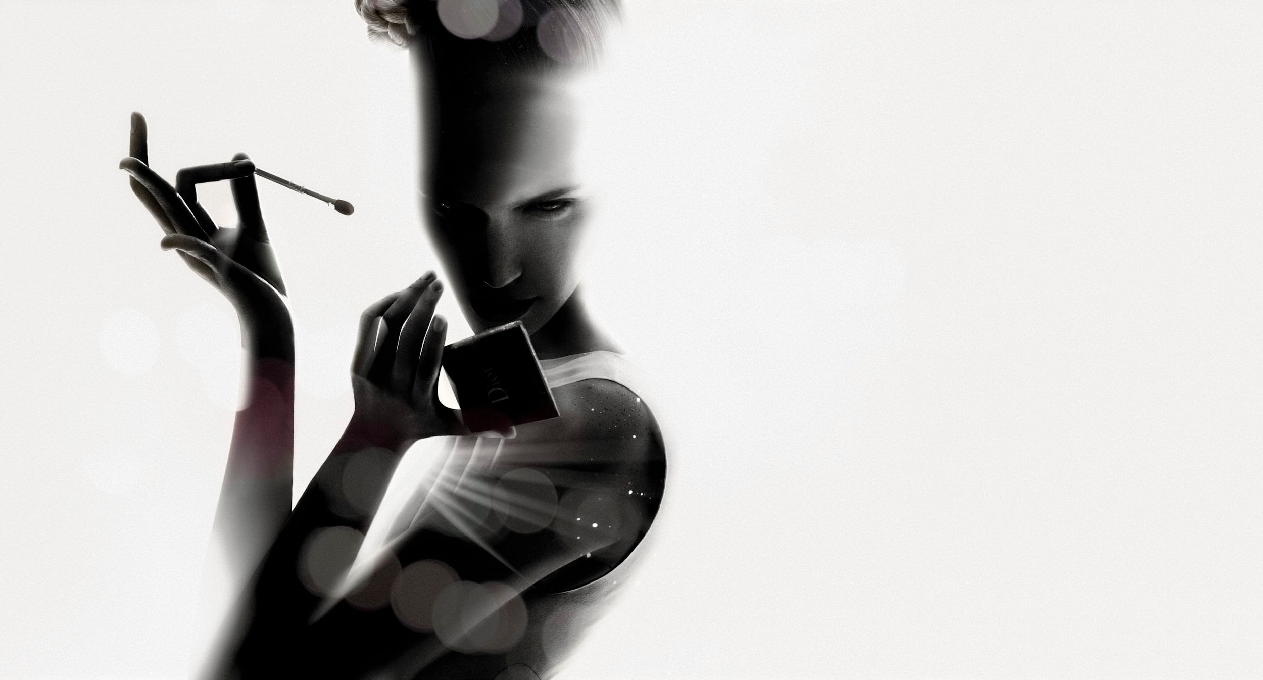 Silhouette of a woman applying makeup, holding a brush and compact mirror against a bright white background.