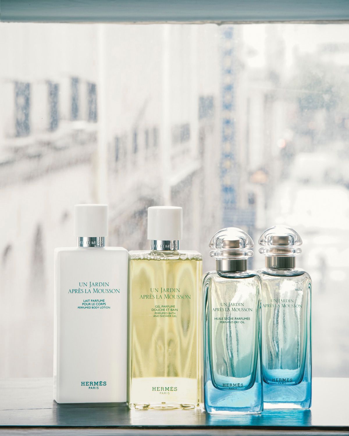 Hermès Un Jardin Après La Mousson fragrance collection featuring body lotion, shower gel, and two eau de toilette bottles.