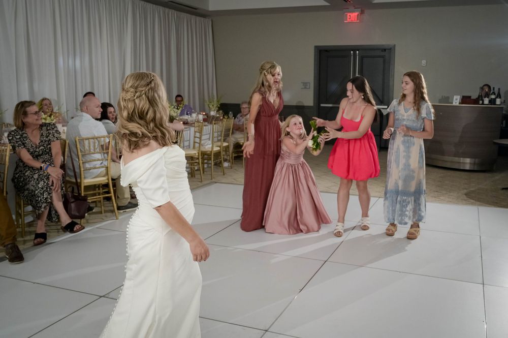 Wedding party dancing and celebrating on white dance floor at reception.