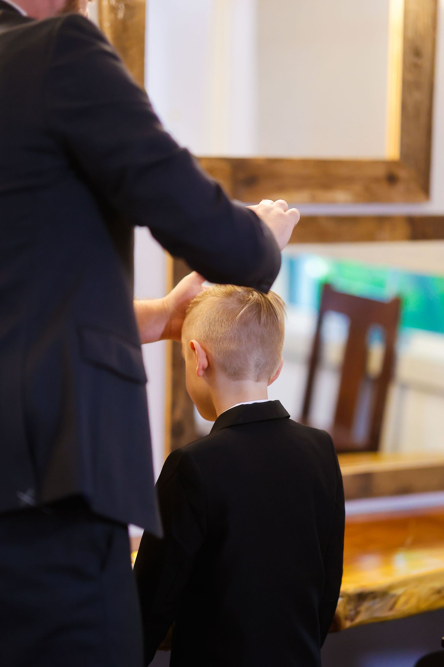 A young child getting final touches on their formal attire before an event.