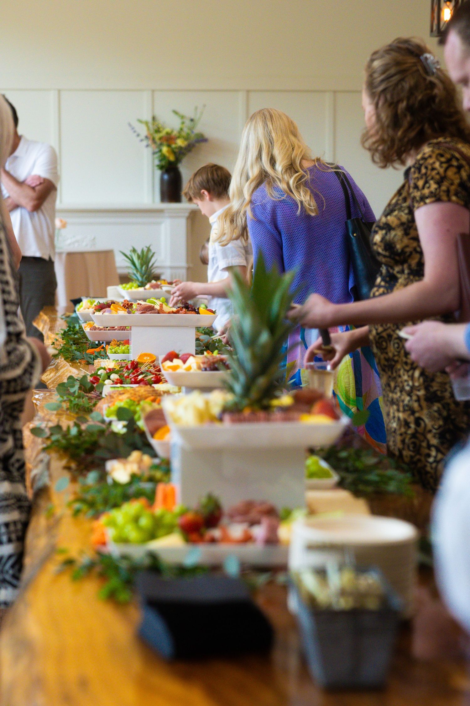 A buffet table spread with food and decorative pineapples at a catered event.
