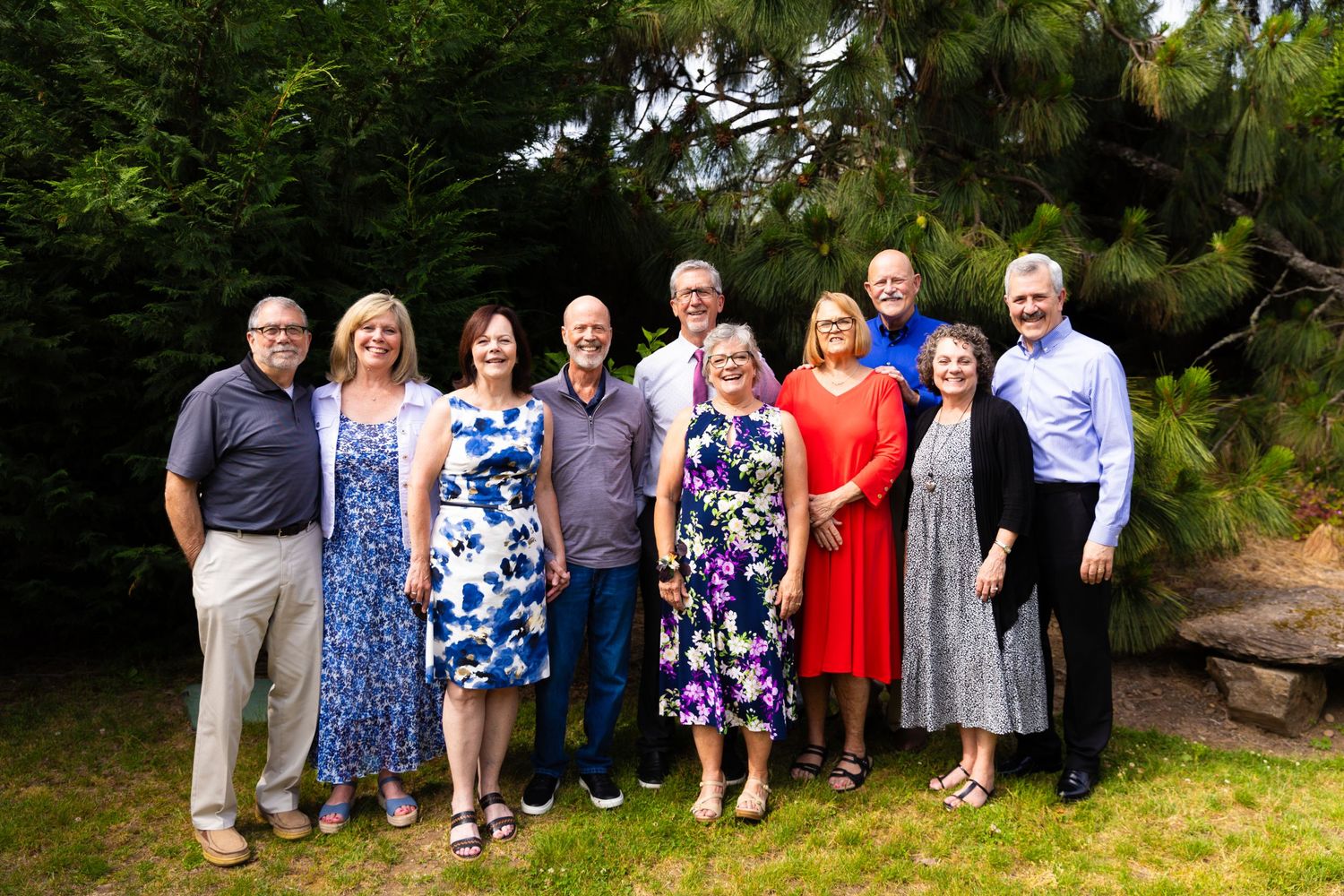 Extended family gathering outdoors with group members wearing casual summer attire.