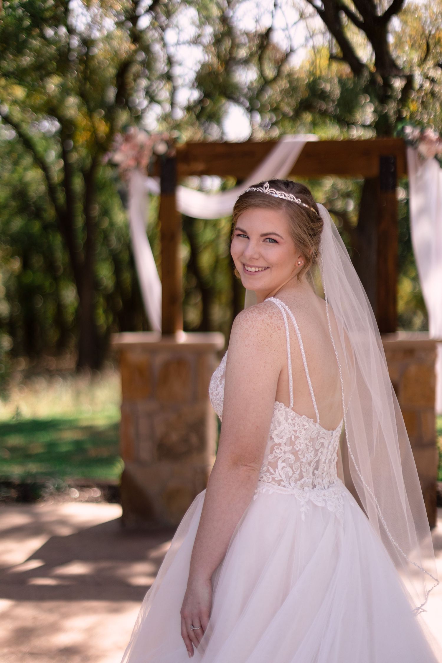 Bride looking back while she is near a water well.