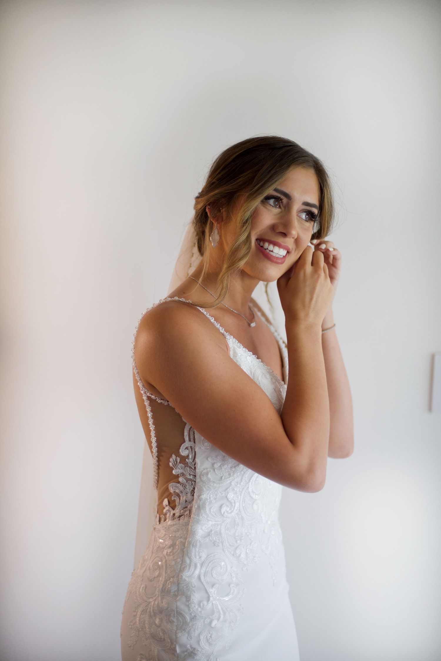 Bride putting on her earrings.
