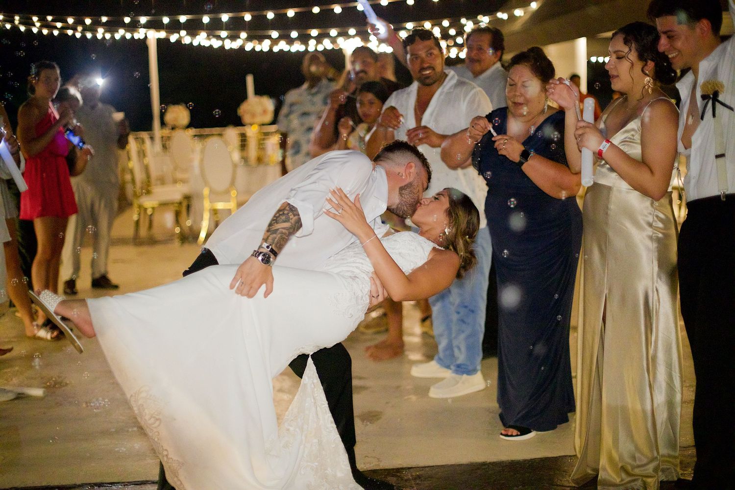 Groom dipping his bride and kissing her during the send off.