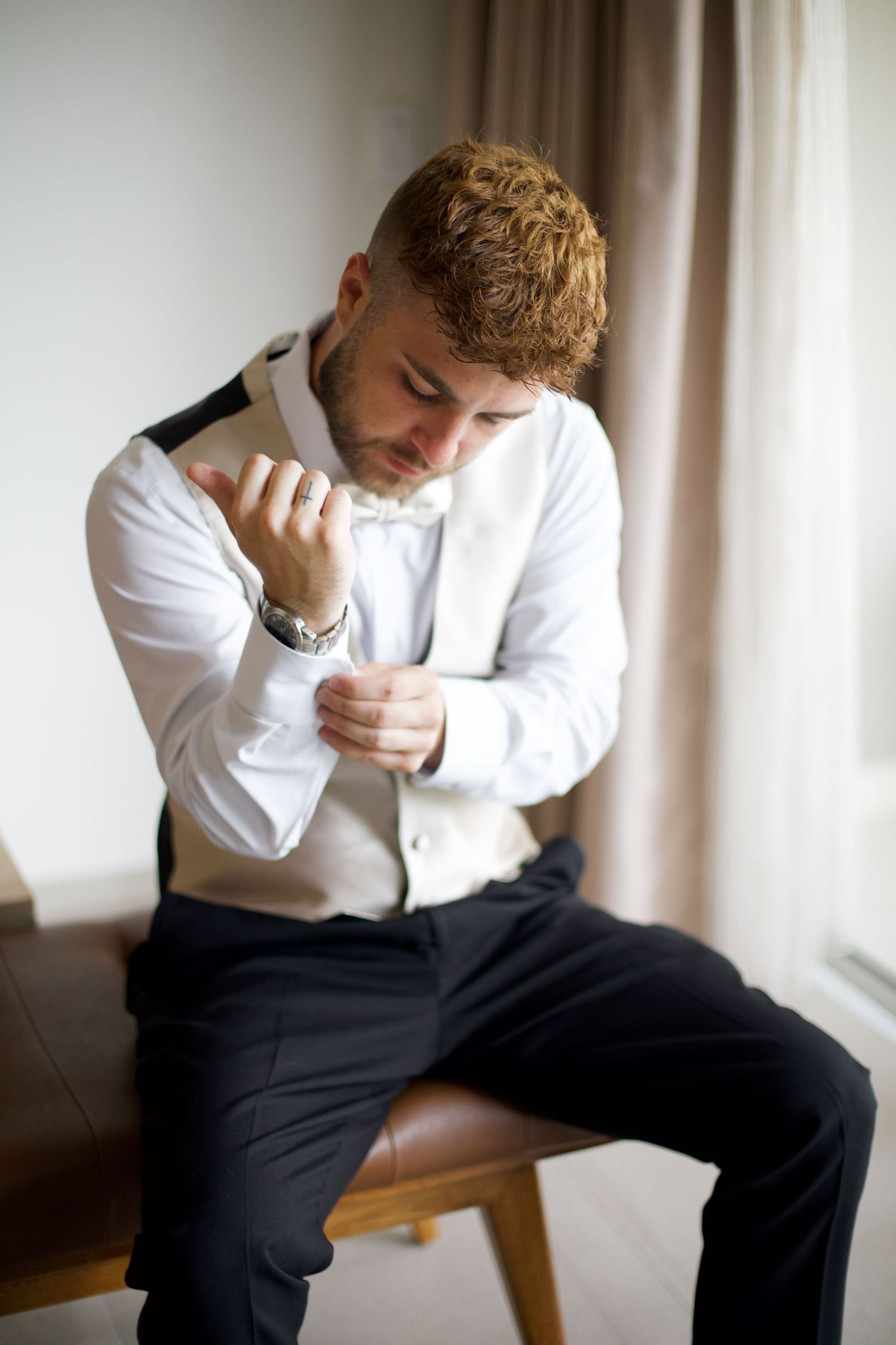Groom getting ready and fixing his sleeve.