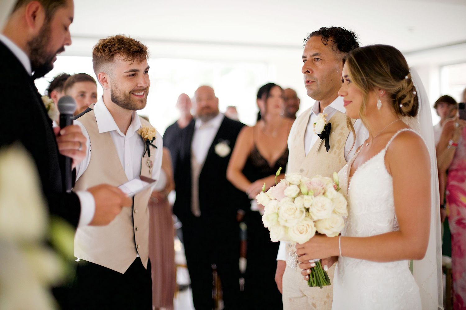 Groom looking and smiling at bride in the aisle.