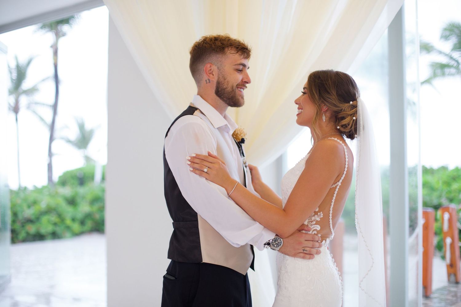 Groom and bride looking and smiling at each other.