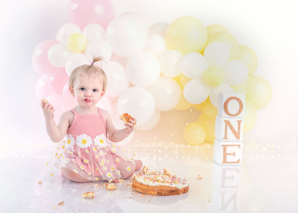 Birthday cake smash photography setup with pastel balloons and decorative ONE letters.