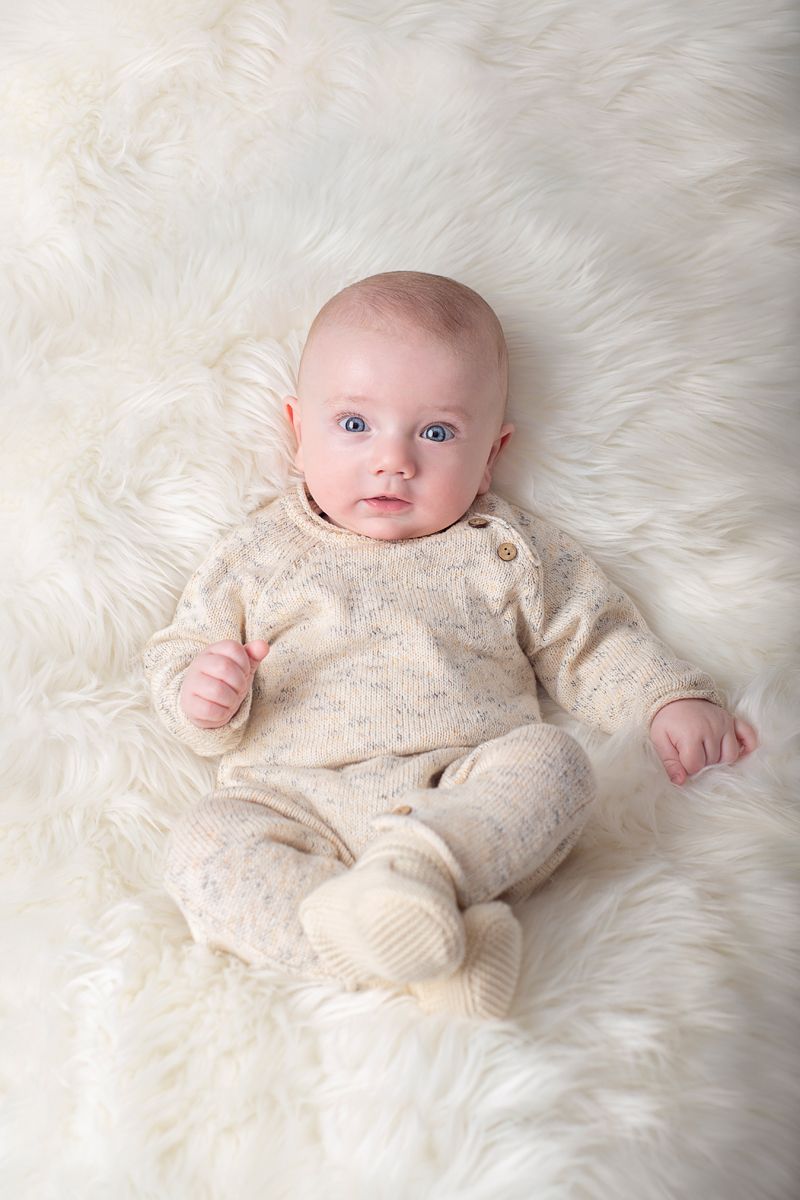 three month baby boy milestone session laying on back in netral colours looking up, in studio Baltimore, Ontario*