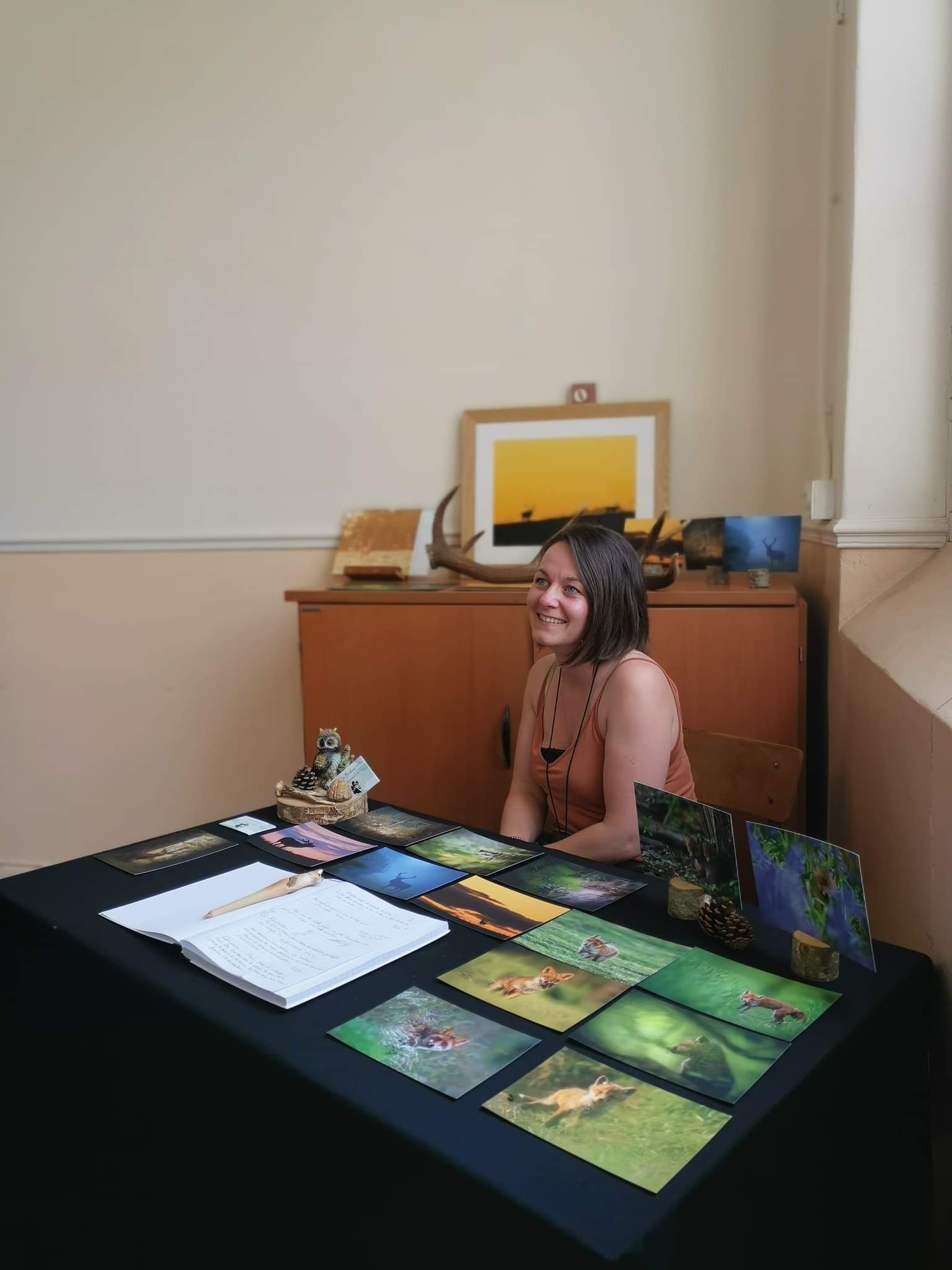 Vendor booth with nature photography and art prints displayed on a table.