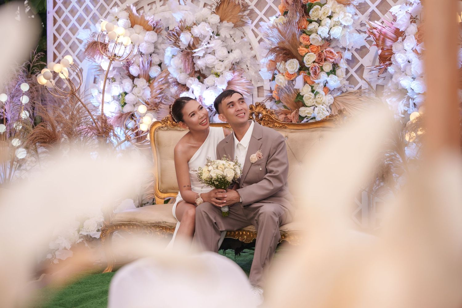 Wedding ceremony setup with pink and white floral arch decorations and seating.