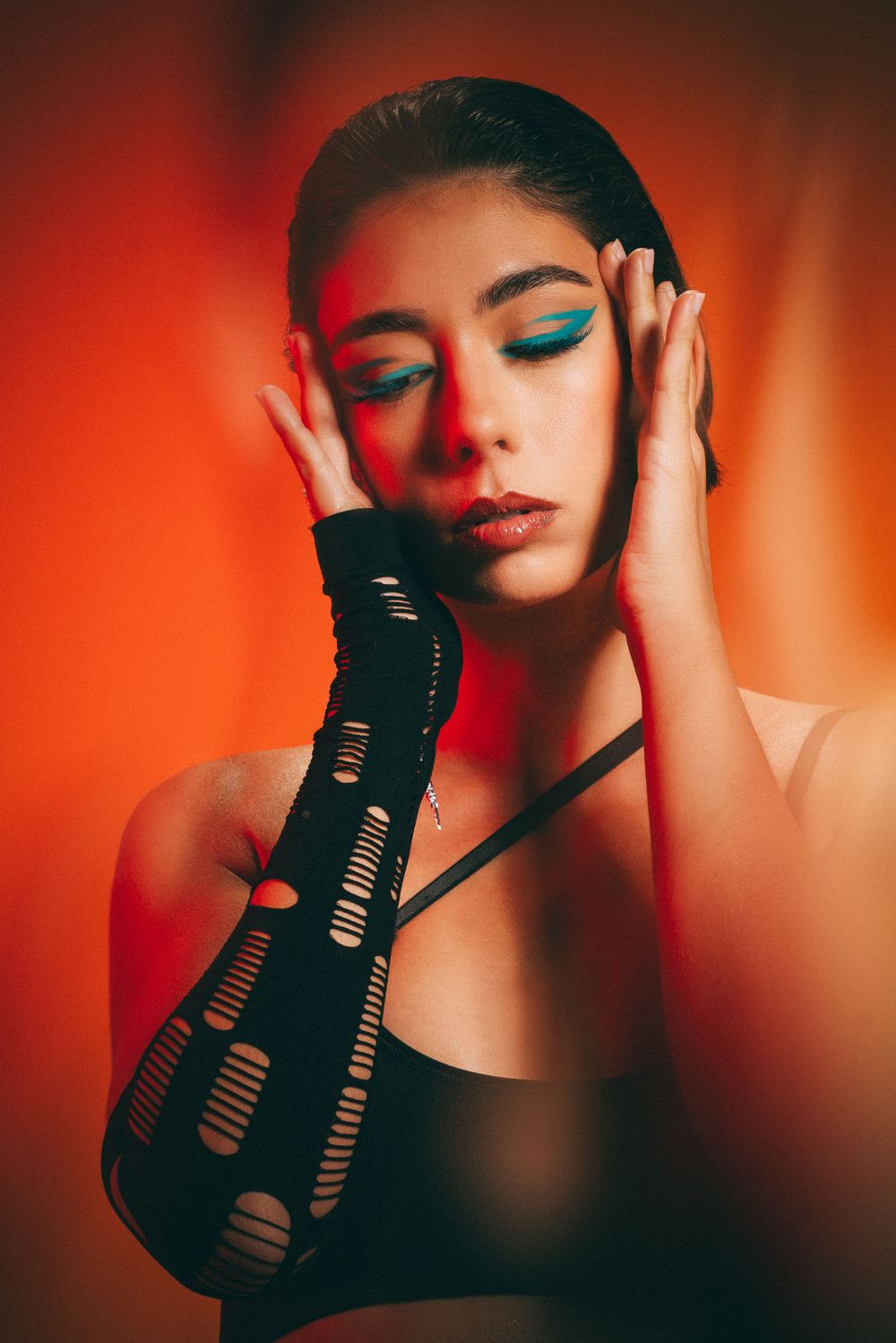 Moody portrait with dramatic red lighting and glamorous styling.