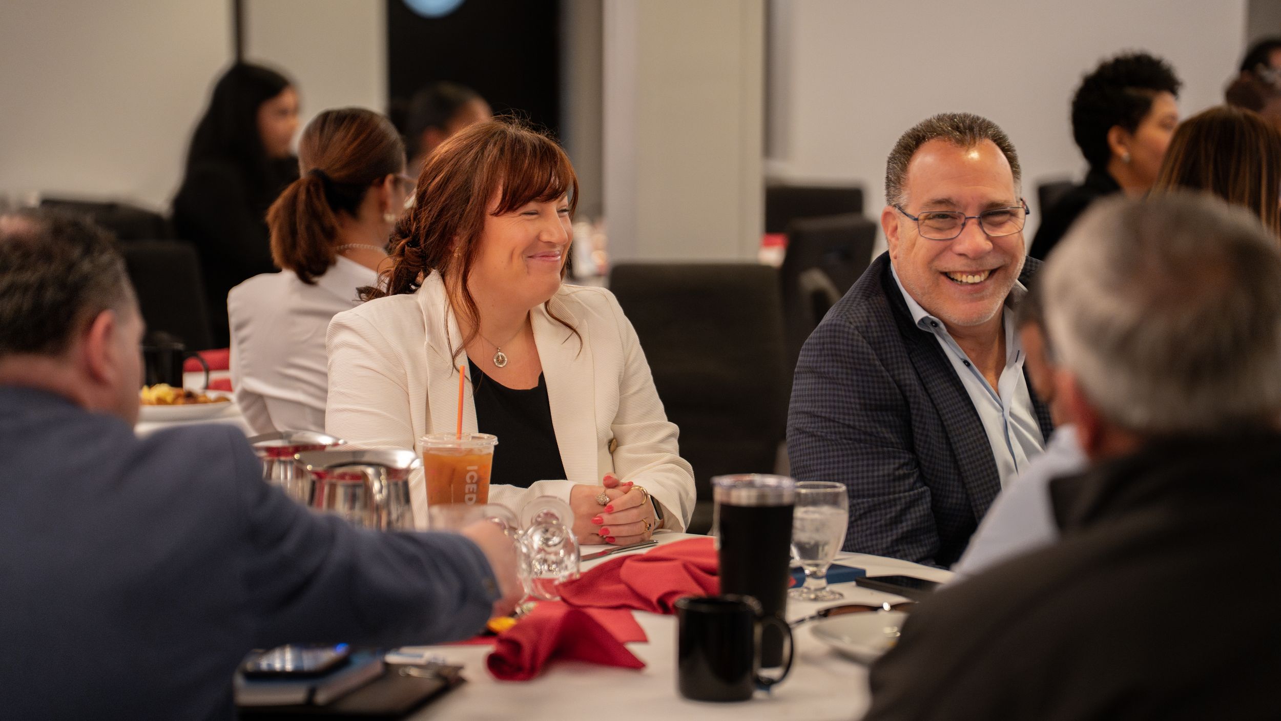 Colleagues engage in lively discussion around a conference table during a business meeting.