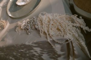 Delicate white lace fabric on wedding dress reflects softly in elegant natural lighting.
