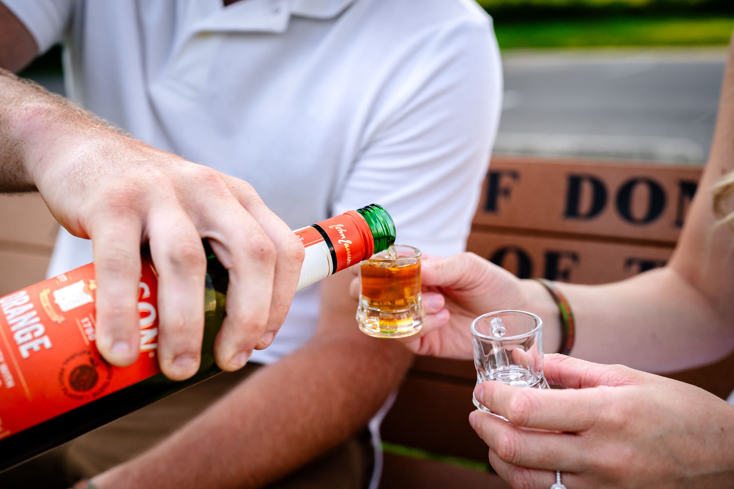Couple sharing drinks and intimate moments with Jameson whiskey bottles in an outdoor setting.