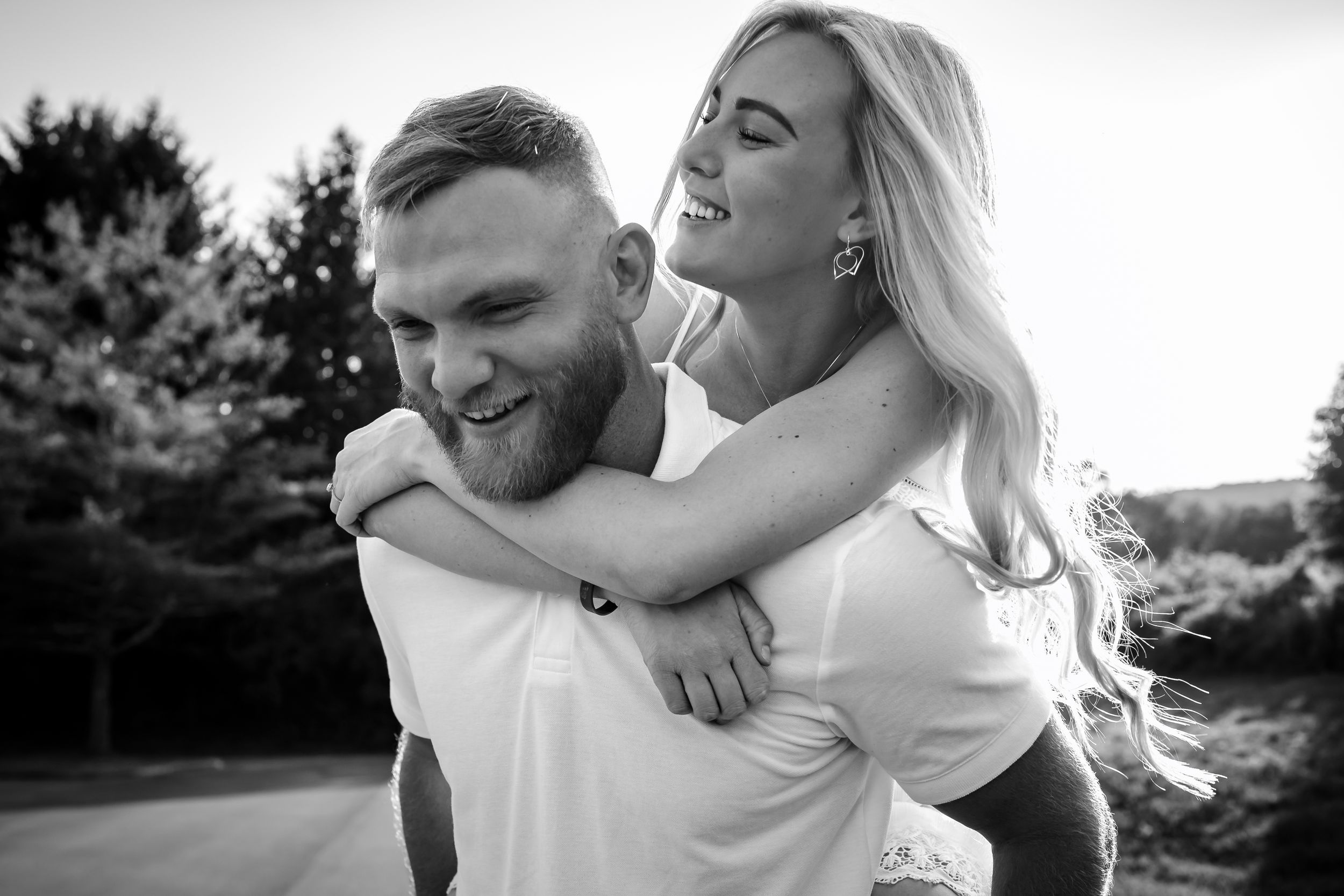 Black and white portrait of couple sharing an intimate moment outdoors.