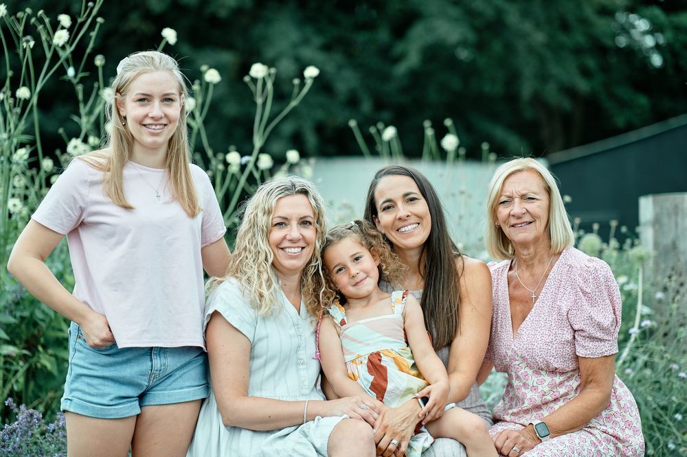 A multi-panel collage showing outdoor family portraits with people embracing and smiling in a garden setting.