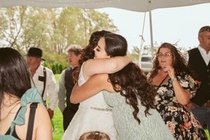 Wedding celebration moment under a white tent during an outdoor reception.