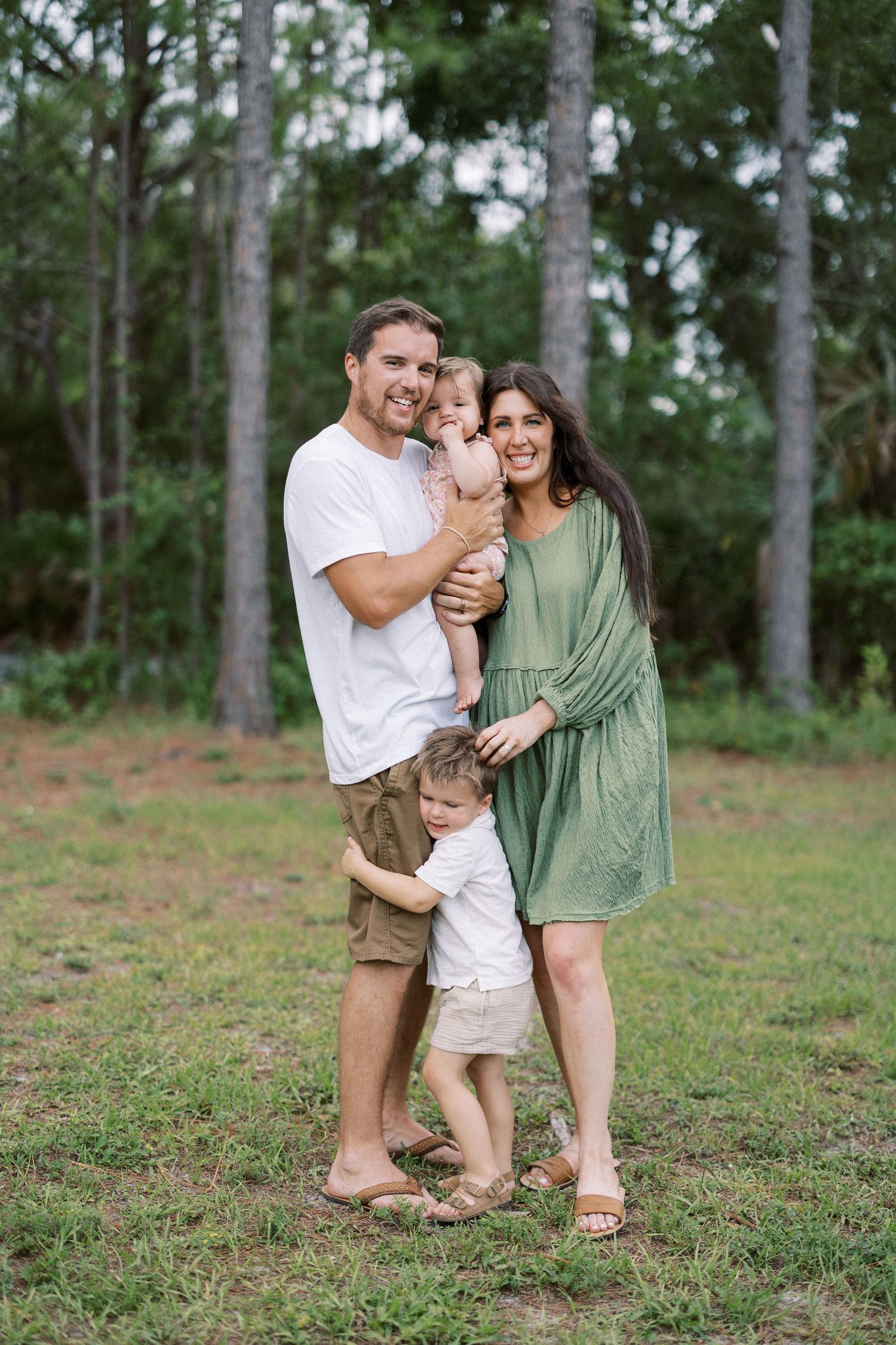 Family sharing joyful moments together while playing outdoors in a wooded setting.
