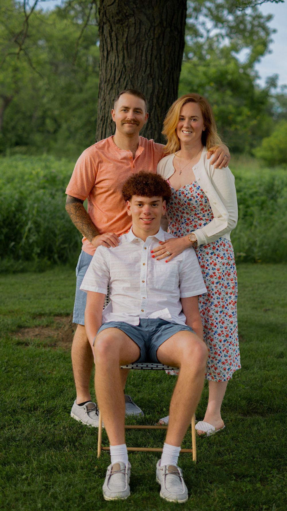 Father carrying his child outdoors during a family portrait session.