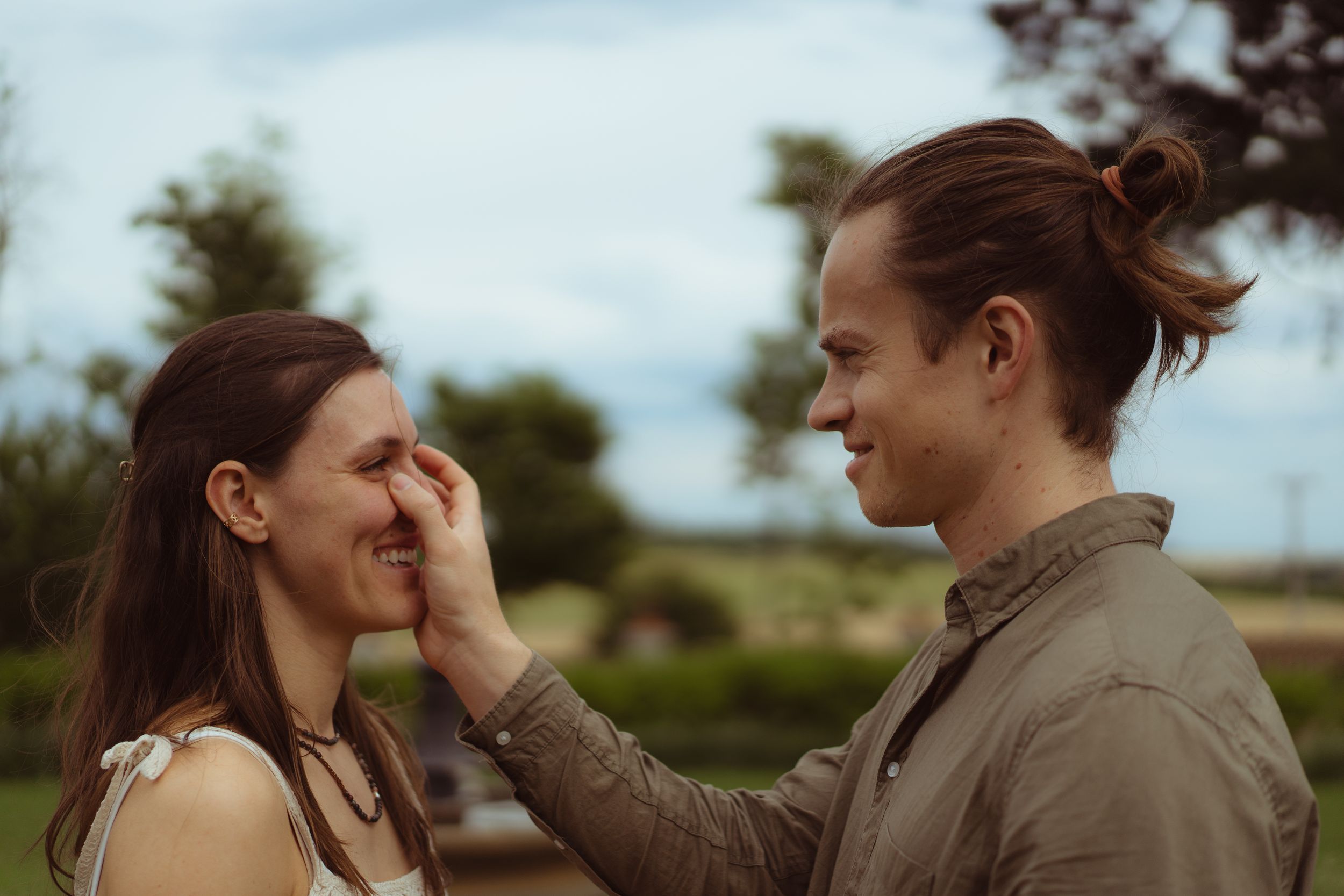 The groom tenderly wipes tears from the brides eyes during the wedding rehearsal