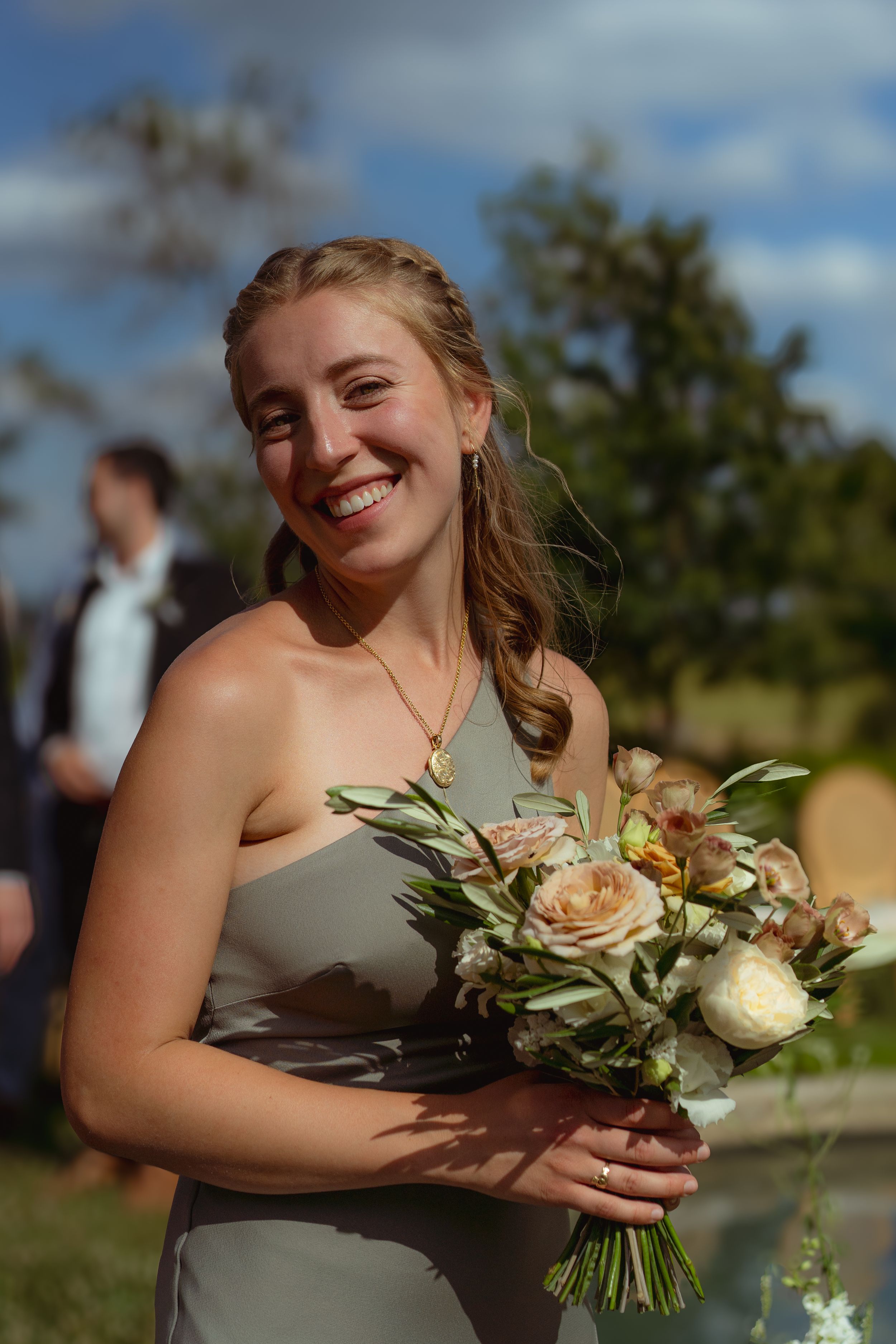 A sunlit bridesmaid smiles to the viewer