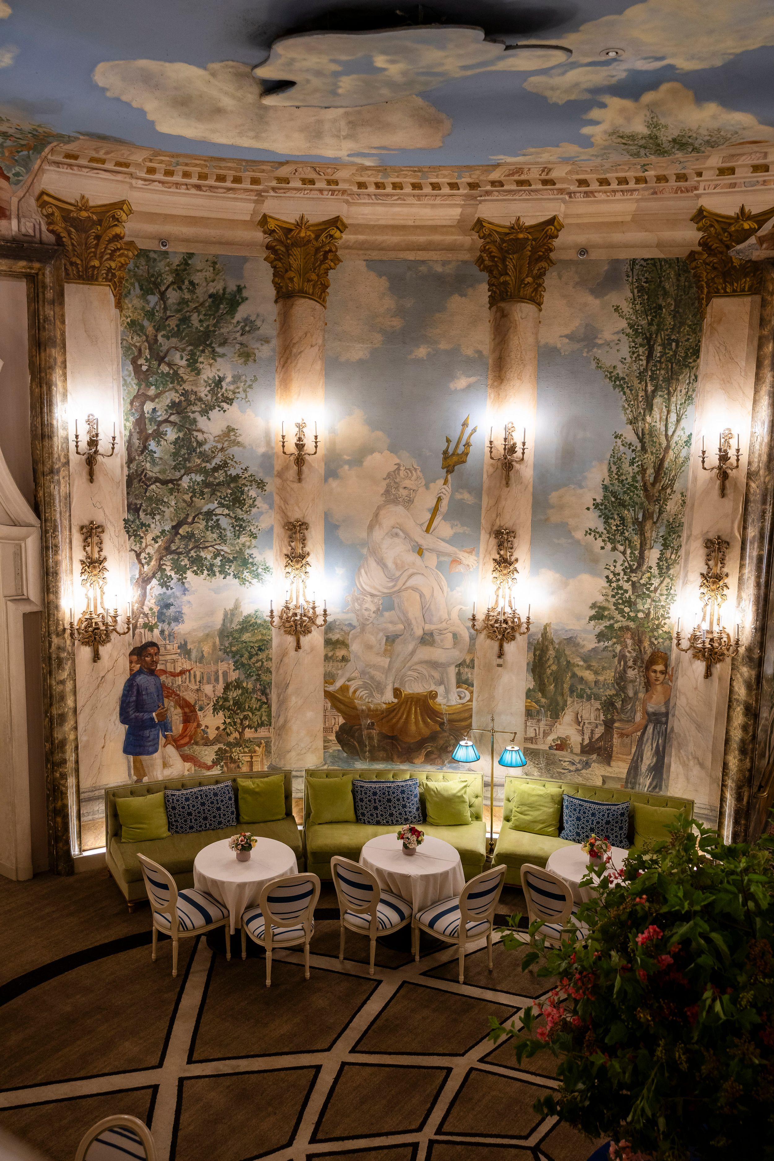 Luxurious dining room with painted pastoral murals, columns and crystal sconces.