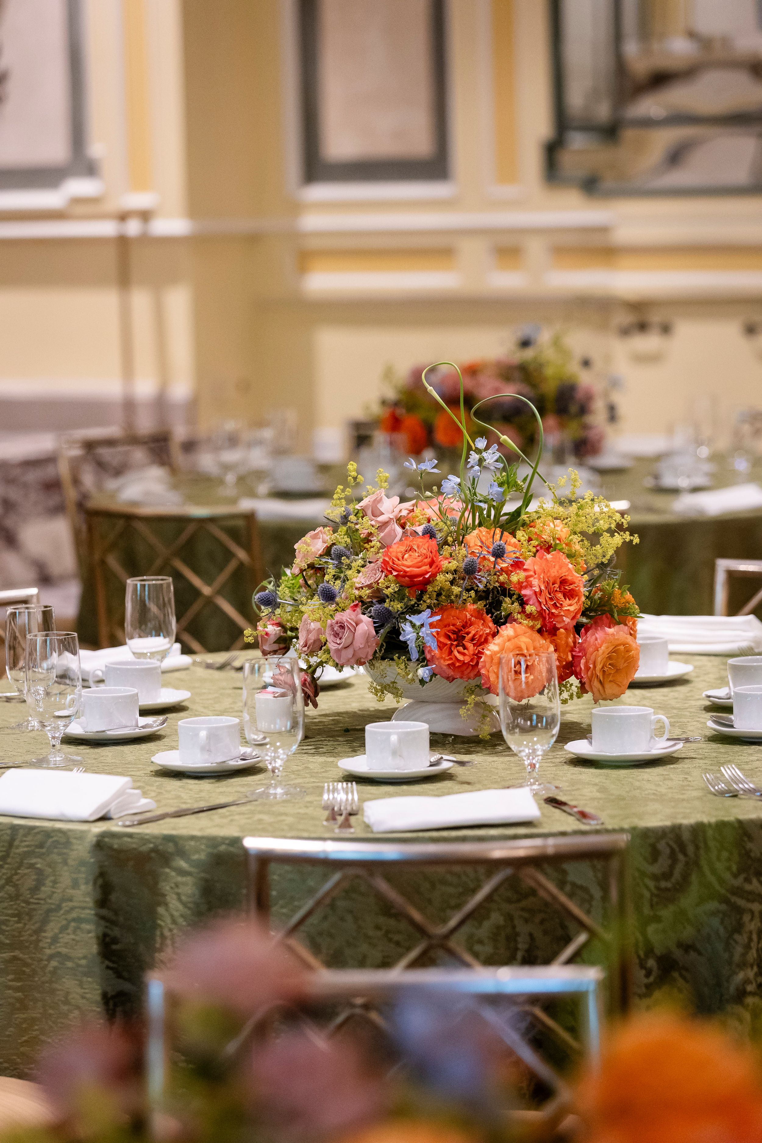 Formal table settings with colorful floral centerpieces and white linens.