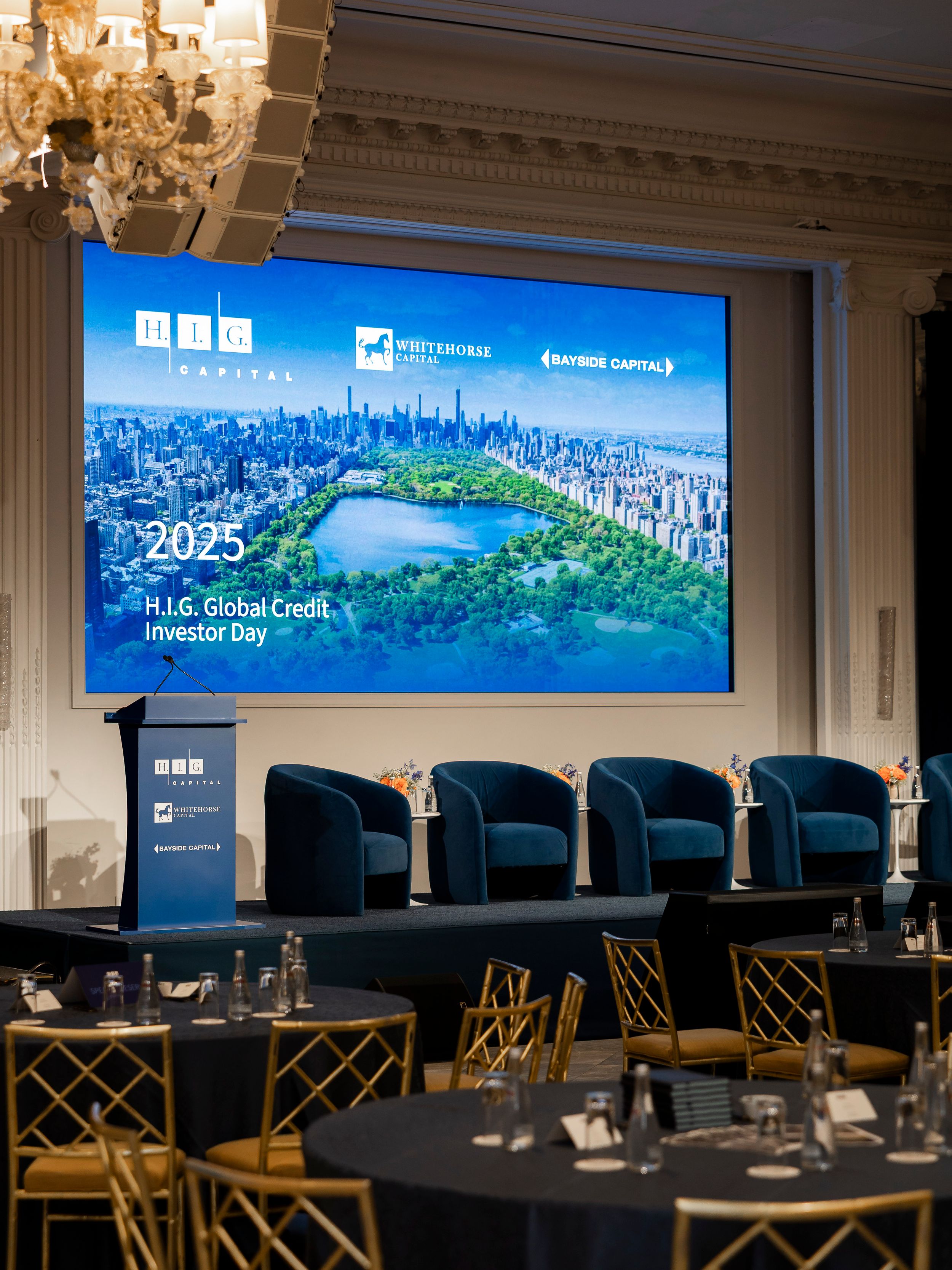 Conference room with elegant columns and wide screen displays showing cityscape presentation.