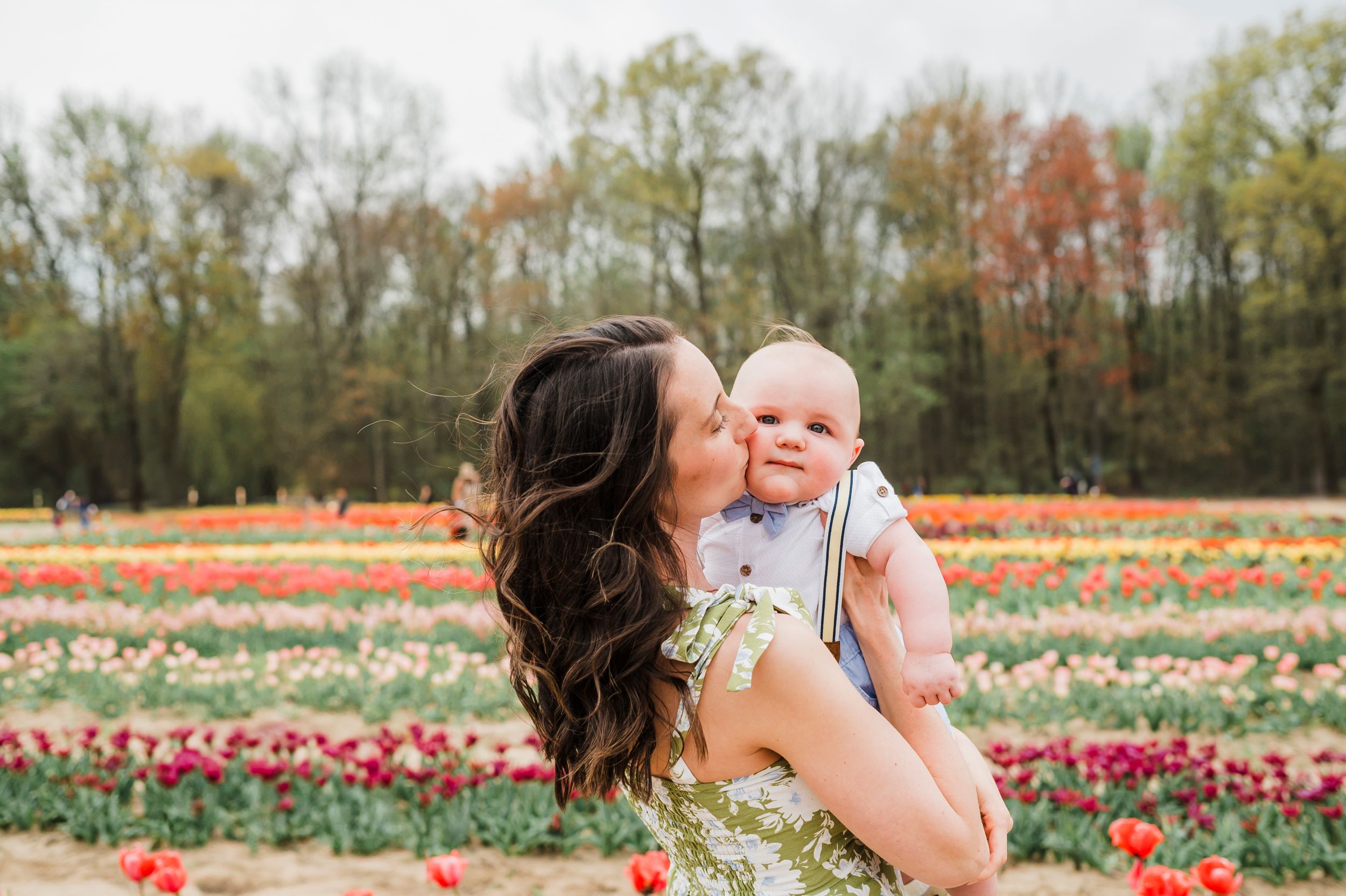 Mother and daughter share joyful moments together in a vibrant spring tulip field with colorful blooms.