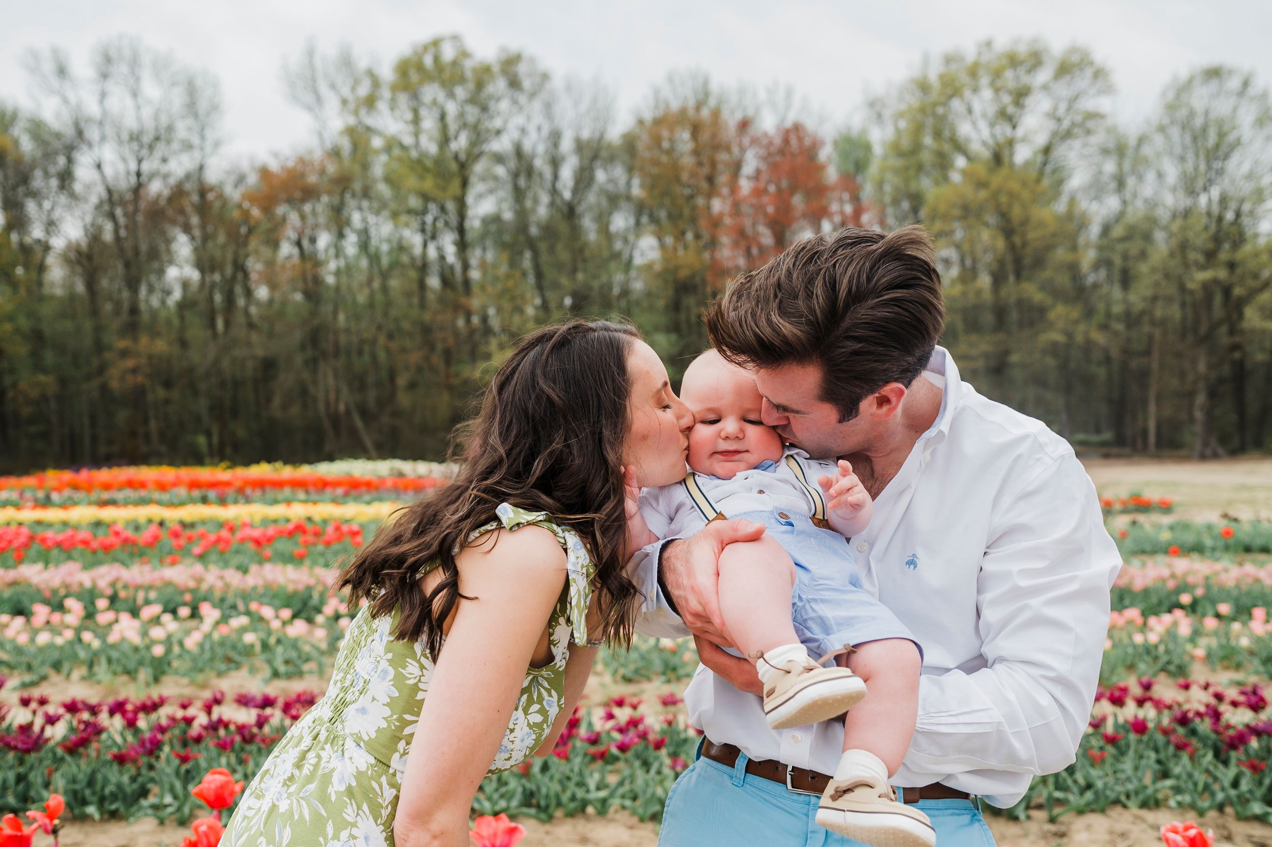 A loving family shares a tender moment together in a vibrant tulip field during springtime.