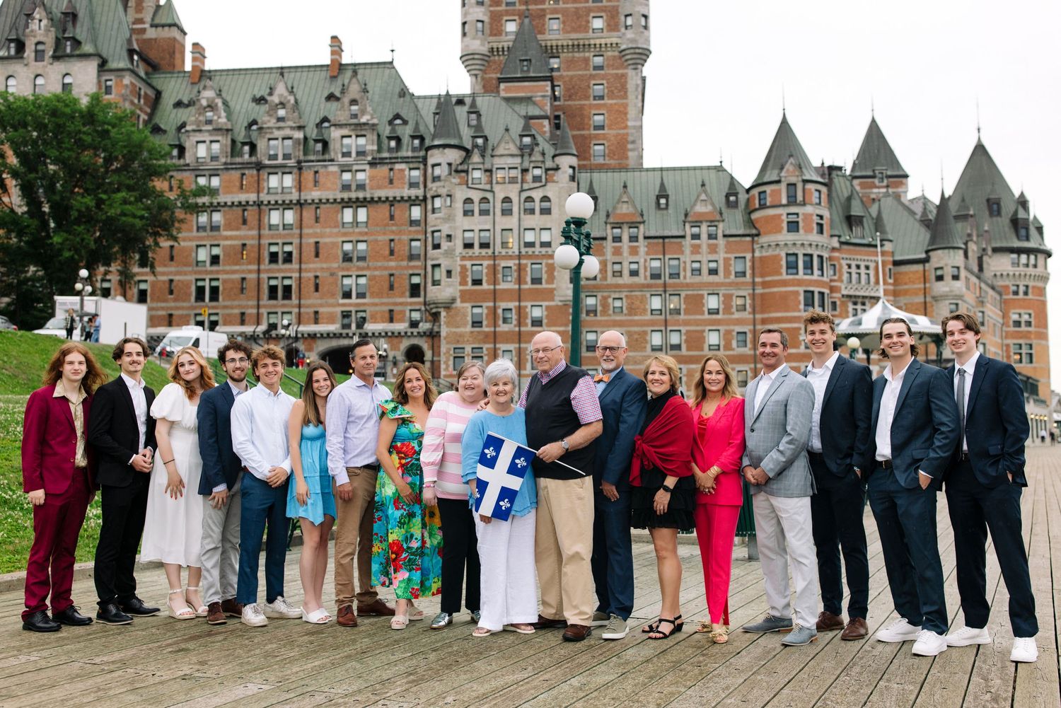 A large group poses for a wedding photo on the terrace of Chateau Frontenac.