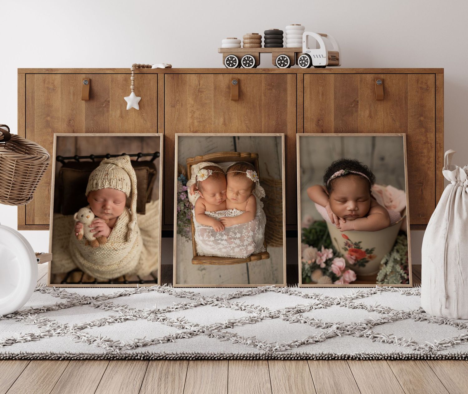 Three vintage-style framed newborn photos displayed on wooden shelf with rustic decor and small toy train on top.