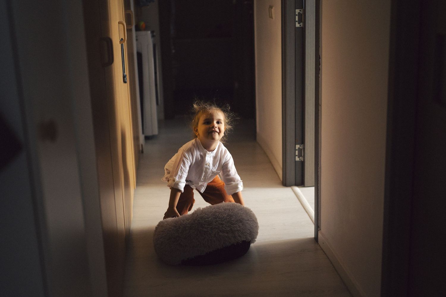 A sequence of five photos showing a person sitting in a dimly lit hallway, captured with dramatic lighting effects.