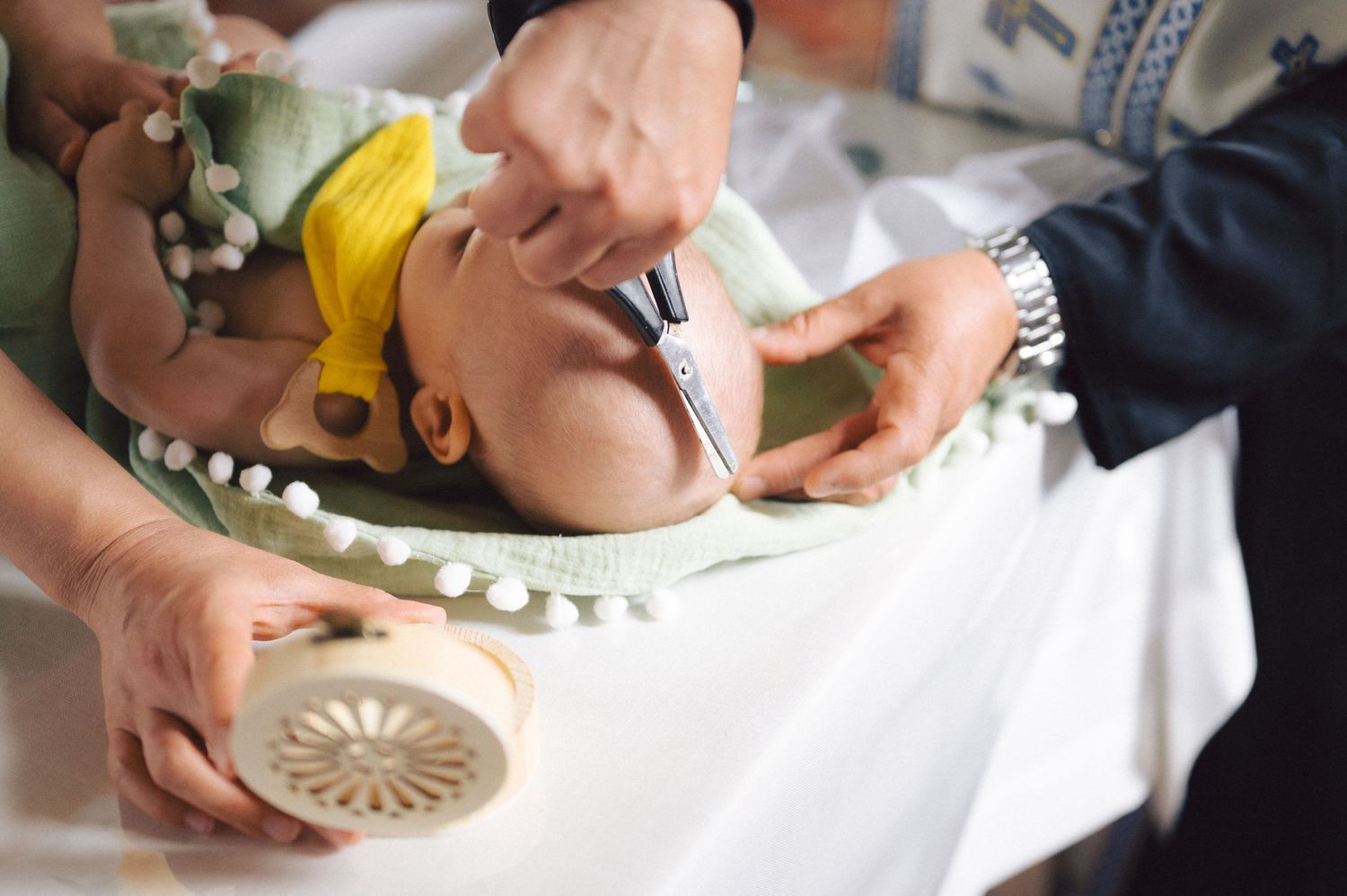 Close-up shot showing hands performing beauty treatment at spa with white towel and beauty tools.