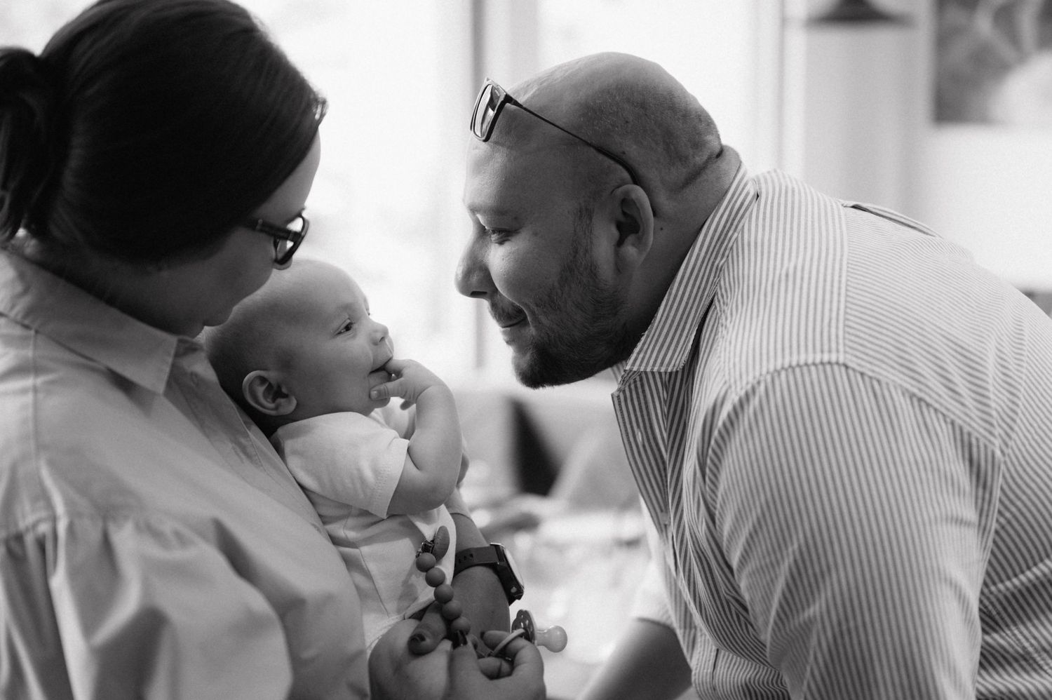 A collection of black and white images showing intimate family moments and interactions between parents and children.