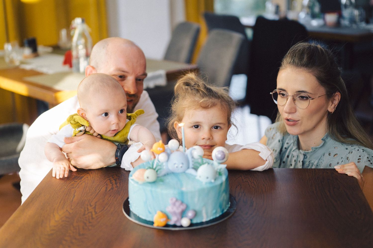 A collage of candid moments at a birthday party showing people gathered around a blue and white cake.