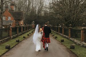 A couple walks down a tree-lined path in winter, adding a romantic touch to the winter garden setting.