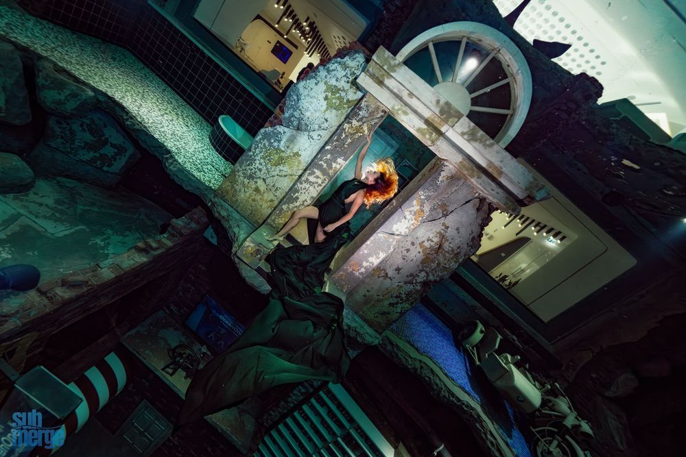 A dark industrial room shows machinery components and mechanical equipment with dramatic low lighting and shadows.