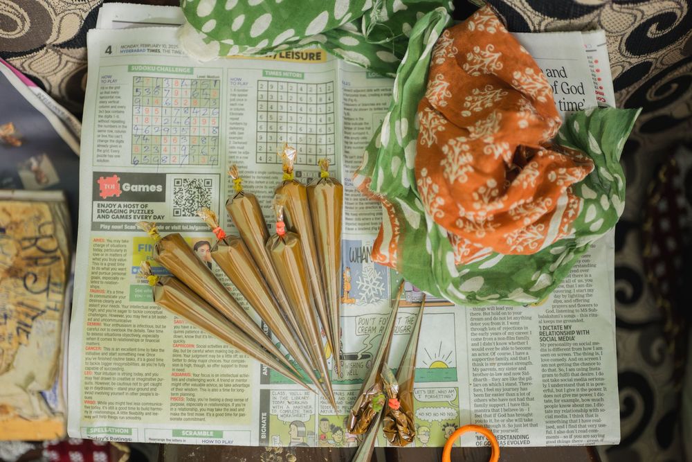 Traditional Indian wedding accessories and food items arranged on a newspaper.