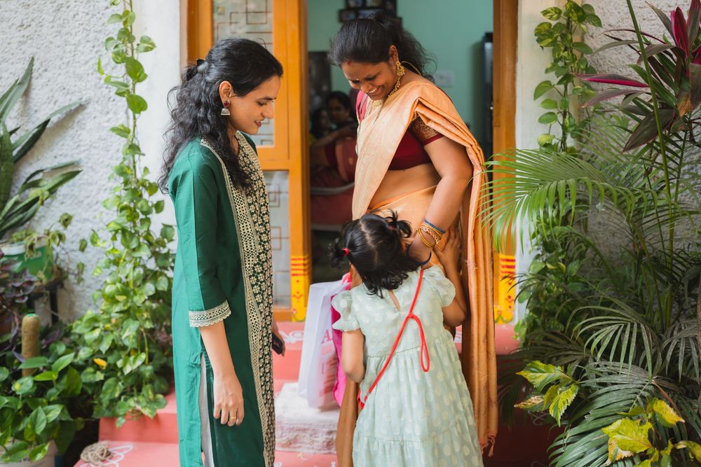 People in traditional Indian dress interacting on a patio with lush greenery.
