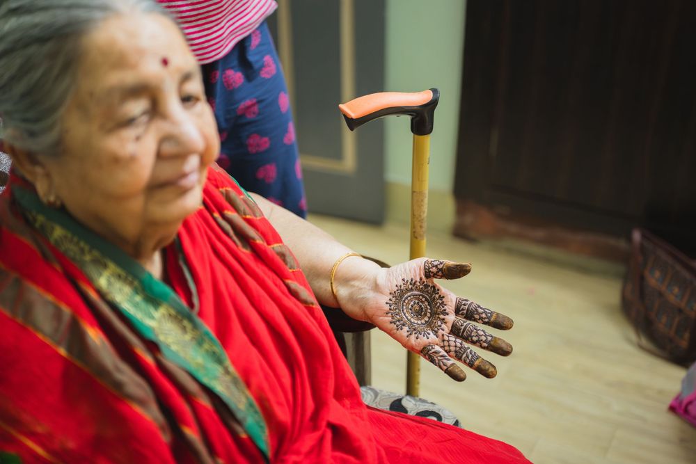 Detailed henna design being displayed on an elderly person's palm.
