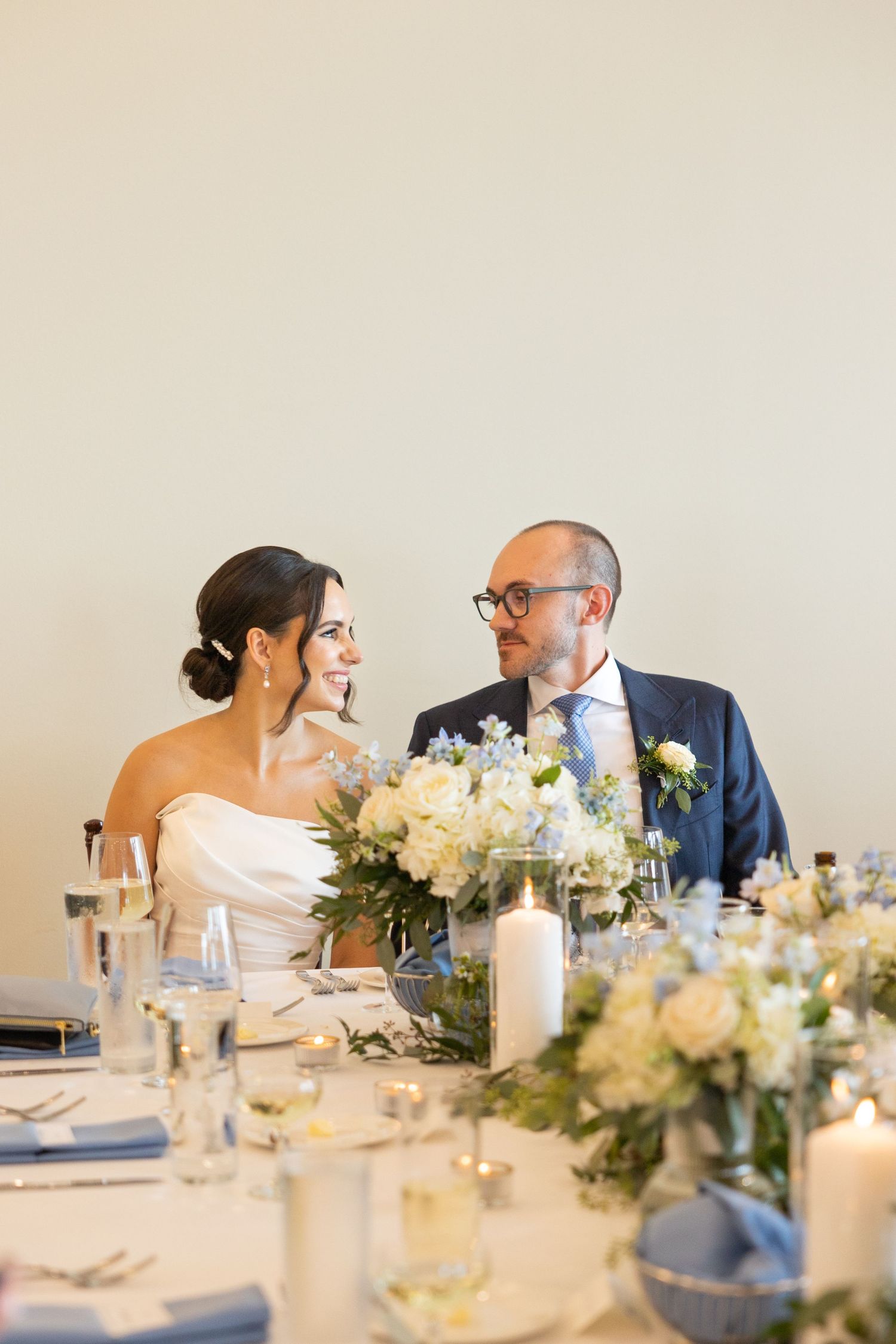 Elegant wedding reception table decorated with white floral arrangements and candles at an indoor venue in Southeast Michigan