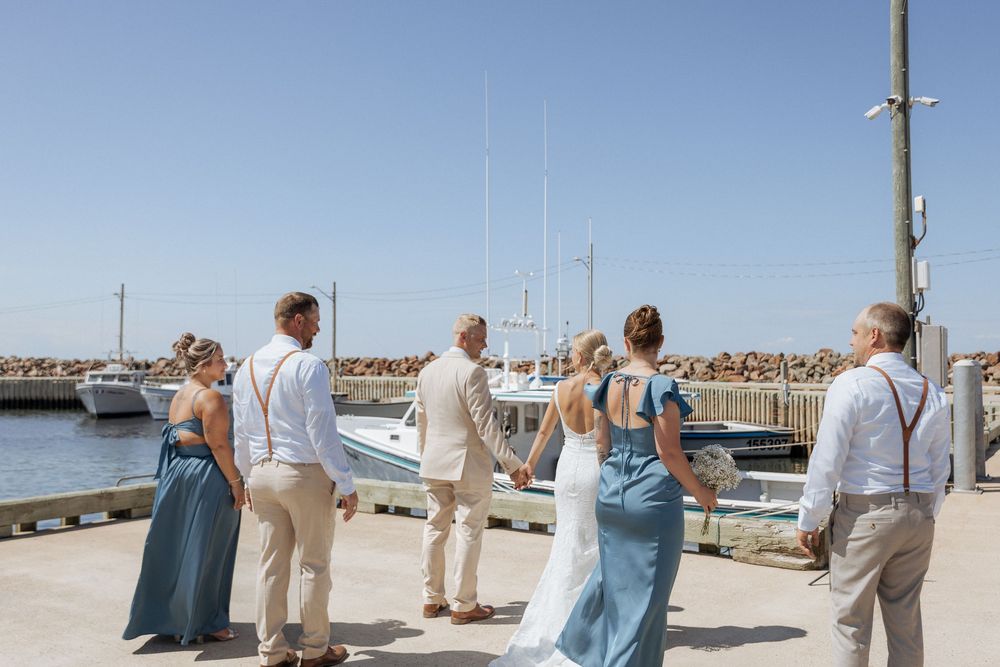 Joyful wedding party portraits at a New Brunswick wharf, Cap Pele beach wedding Elegant bridal party photos in Dieppe New Brunswick.