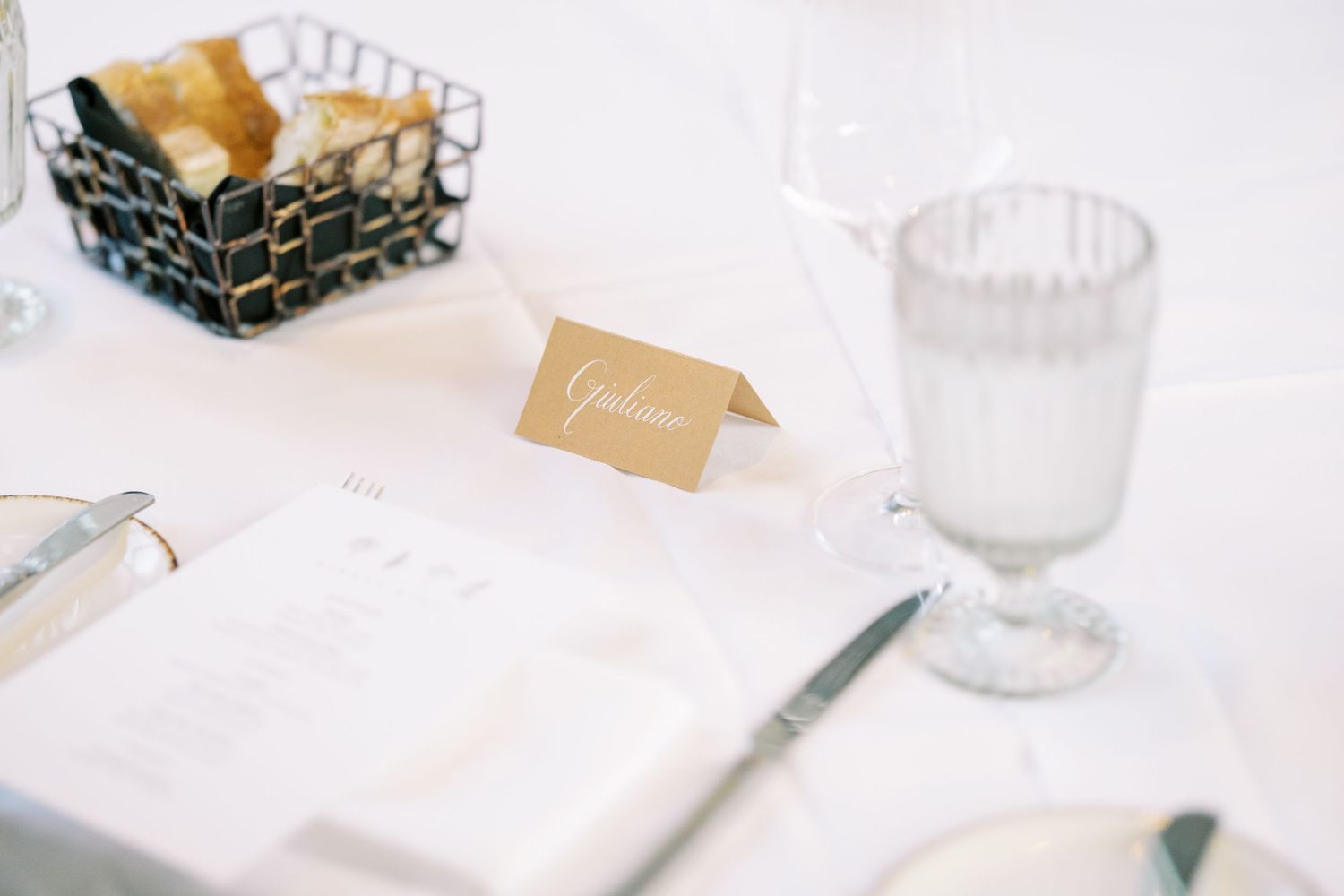 Modern minimalist wedding decor flatlay with white stationery, envelopes, ribbon and fine art styling at Ninety Acres and Pendry Natirar