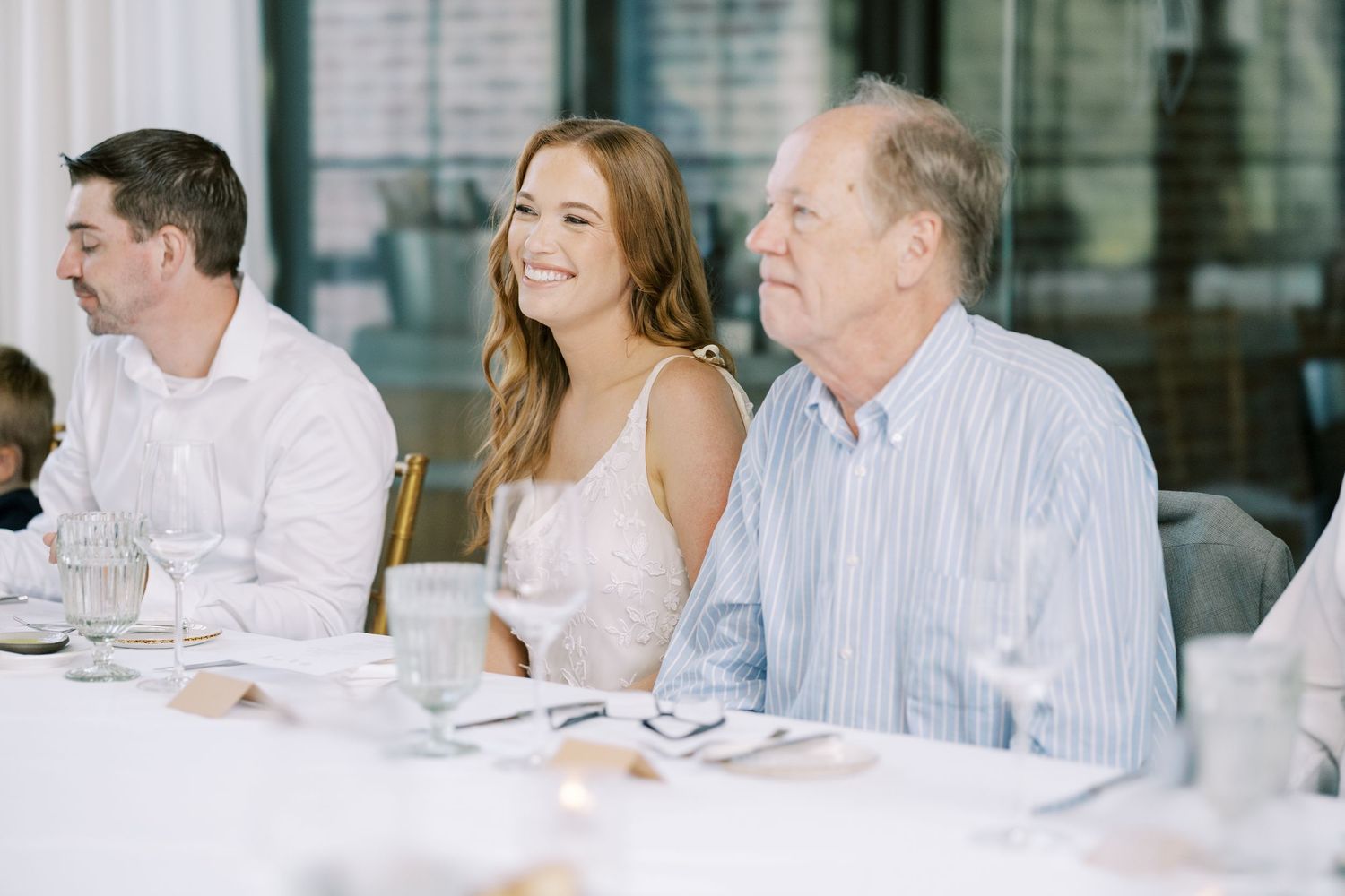 People seated at an elegant white-tablecloth dining table during a formal event at Ninety Acres and Pendry Natirar.