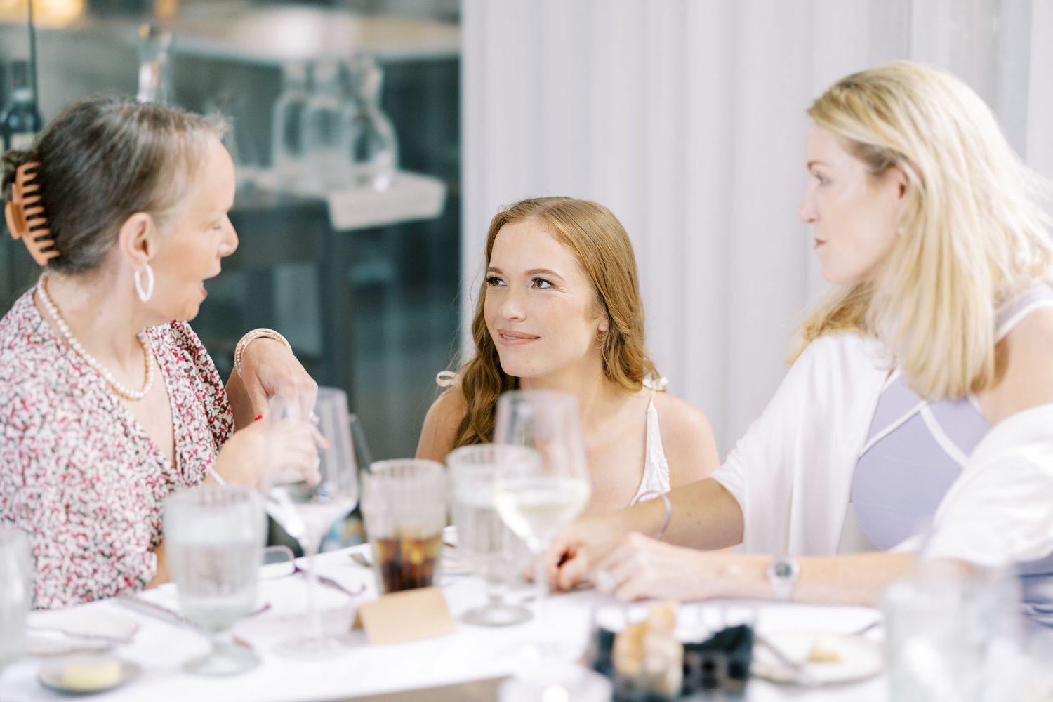 A bride and her moms enjoy a dining experience together during a social gathering at Ninety Acres and Pendry Natirar.