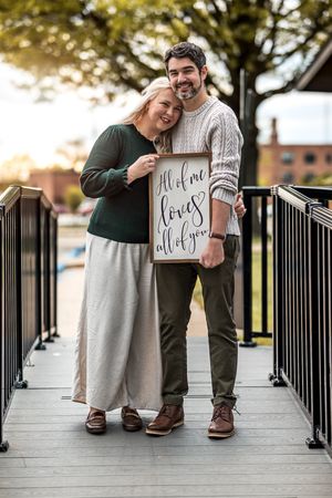 A series of romantic photos taken outdoors showing a couple sharing a special moment on a deck with signs.