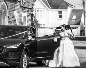 A set of black and white wedding photos showing a luxury car, bridal gown details, and elegant venue shots.
